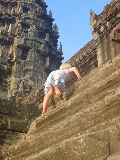 A challenge for the girls climbing up the steep, worn steps to the central gallery of Angkor Wat. The world's largest religious building.